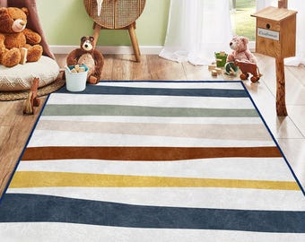 May include: A rectangular area rug with horizontal stripes in shades of blue, gray, brown, yellow, and white. The rug has a dark blue border and is placed on a wooden floor. The rug is designed for a child's room.