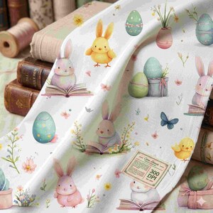 Könnte beinhalten: Weißer Stoff mit Ostermotiv, der Hasen, Küken und dekorierte Eier in Aquarell zeigt. Das Muster umfasst offene Bücher, Blumen und Schmetterlinge. Der Stoff hat eine weiche, pastellfarbene Farbpalette mit Vintage-Ästhetik.