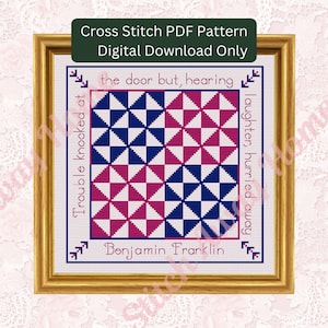 Könnte beinhalten: Ein gerahmtes Kreuzstichmuster mit einem geometrischen Design in Blau und Rosa. Der Text "Trouble knocked at the door but, hearing laughter, hurried away" und "Benjamin Franklin" sind enthalten. Der Rahmen ist goldfarben.