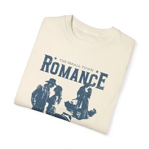 Comfort Colors Shirt in the Color ivory. Cowboy/Western Romance Book Shirt. Text:The small town romance, love stories of the real west, western love trails;.