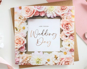 May include: A white card with a floral border and the text "On your Wedding Day" in gold lettering.