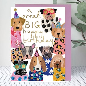 May include: A birthday card featuring a white background with a group of dogs wearing party hats and colourful clothes. The text "a great BIG happy birthday" is written in gold lettering.