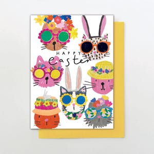 May include: A white greeting card with a yellow envelope features whimsical illustrations of animal faces wearing sunglasses and hats. The text "Happy Easter" is written in cursive. The animal faces include cats and rabbits.