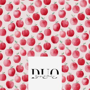 May include: A pattern of red watercolor apples with green leaves on a light pink background. The apples vary in size and are evenly spaced. A white rectangle at the bottom right contains the text "DUO Designed Studio" in black.
