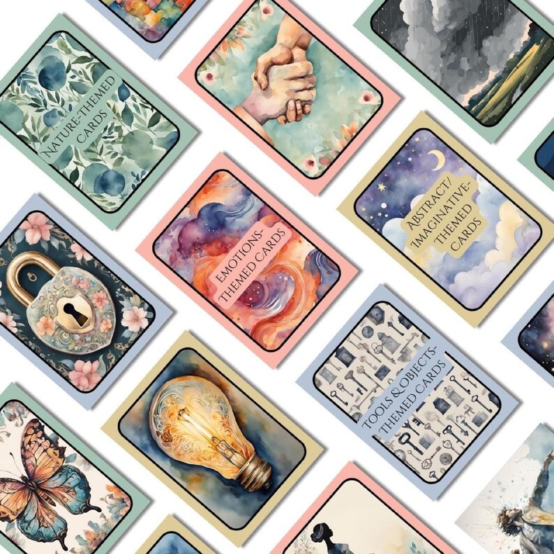 Overhead layout showing themed storytelling cards grouped by category: nature, emotions, abstract/imaginative, and tools/objects. Cards show watercolor illustrations like hands, keys, clouds, and butterflies.