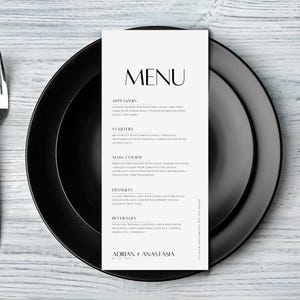 Peut inclure: Un menu de mariage noir et blanc avec le titre "MENU" en gras, police sans empattement. Le menu comprend des amuse-gueules, des entrées, un plat principal, des desserts et des boissons. Le bas du menu indique "ADRIAN + ANASTASIA" dans une police simple, sans empattement.
