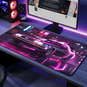 May include: A pink and black gaming mouse pad with a futuristic car in the center. The car is surrounded by neon lights and a city skyline in the background.