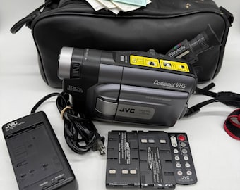 Videocámara compacta VHS JVC unisex, talla única, color gris, modelo GR-AXM511U, con zoom de 100x y monitor LCD.