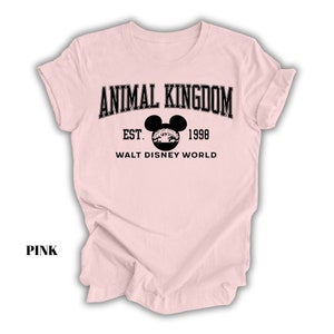 a pink shirt with an animal kingdom logo on it