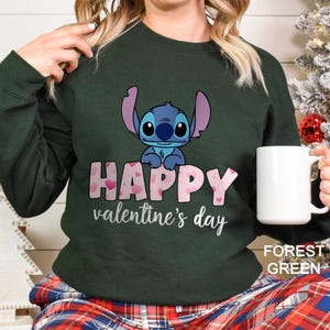 a woman holding a coffee mug in front of a christmas tree