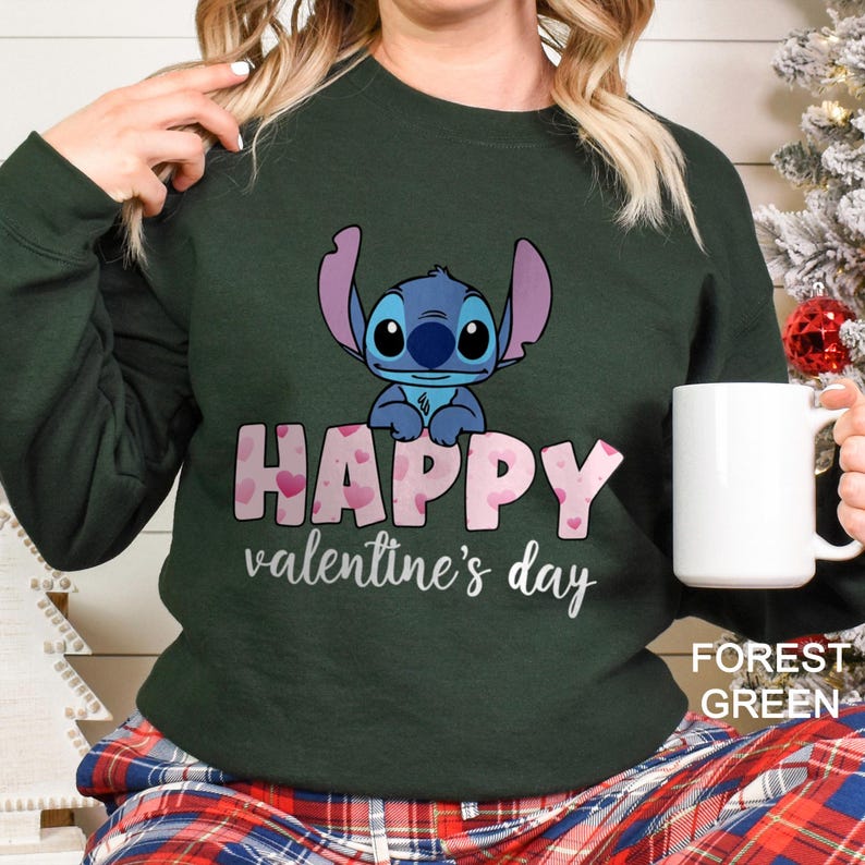 a woman holding a coffee mug in front of a christmas tree