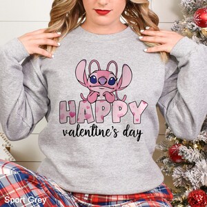 a woman wearing a happy valentine's day sweatshirt