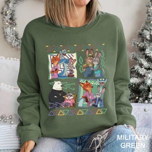 A woman wearing a green sweatshirt with a colorful graphic design featuring cartoon animal characters.