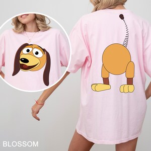 a woman wearing a pink shirt with a cartoon dog on it