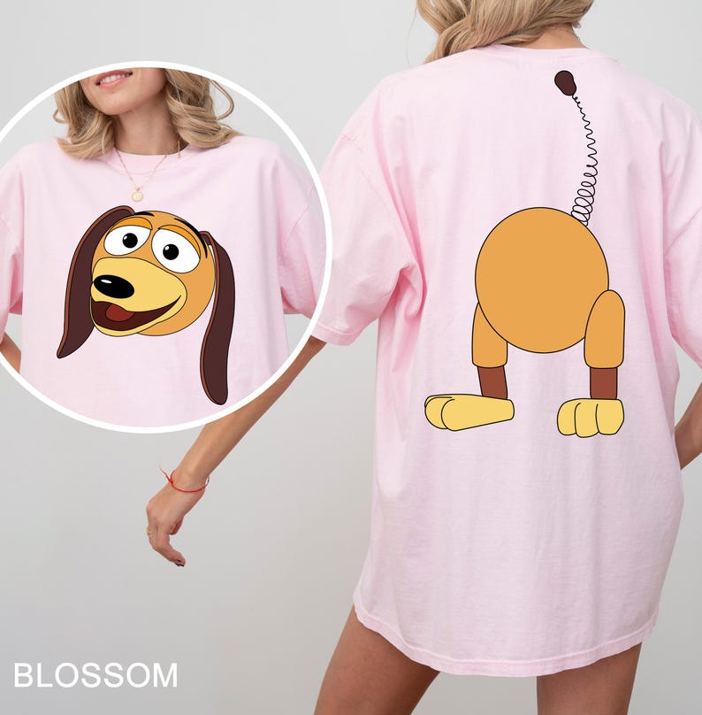 a woman wearing a pink shirt with a cartoon dog on it