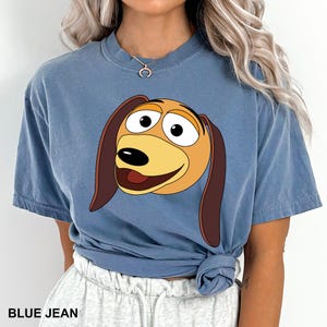 a woman wearing a blue shirt with a cartoon dog on it