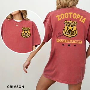 A red t-shirt with a police department logo and text, including the words "Zootopia Police Department" and "The newly appointed Police Department".