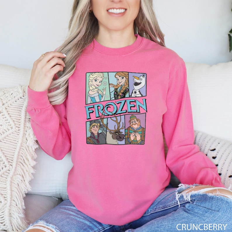a woman sitting on a couch wearing a pink sweatshirt
