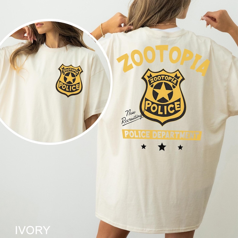 A woman wearing a white t-shirt with a yellow and black police department logo on the back.