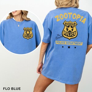 A woman wearing a blue t-shirt with a police department logo on it.