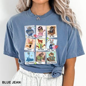 A woman wearing a blue t-shirt with a graphic design of cartoon animal characters and their names.