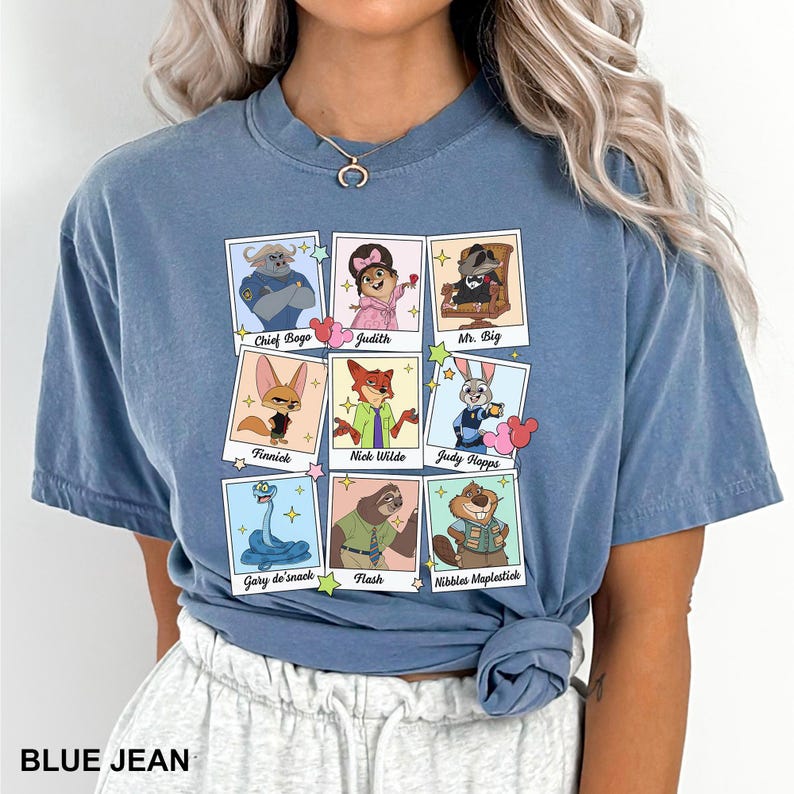 A woman wearing a blue t-shirt with a graphic design of cartoon animal characters and their names.