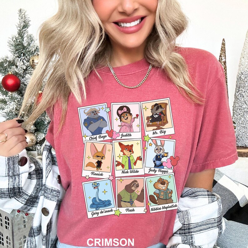 A woman wearing a pink t-shirt with a graphic of cartoon characters from the Disney movie "Jurassic Park" and a necklace.