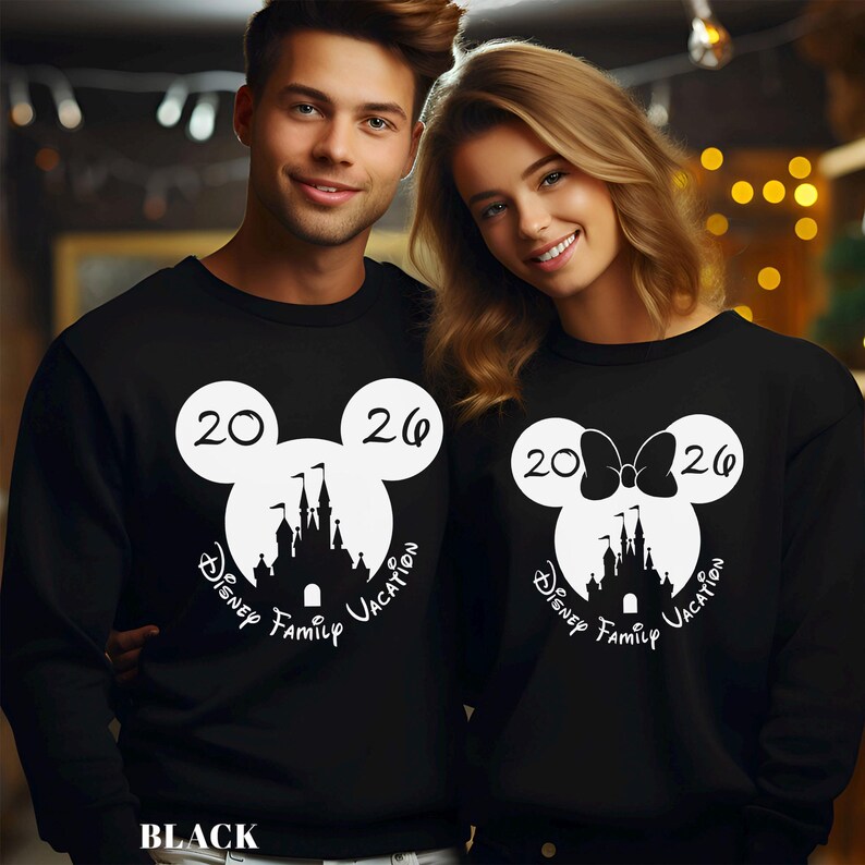 A man and a woman are standing together, both wearing black tops with white Mickey Mouse-like designs and text.