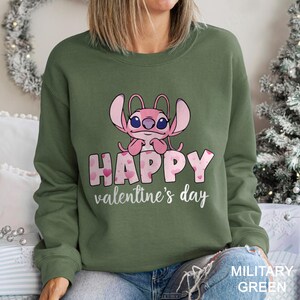 a woman wearing a green sweatshirt with a pink crab on it