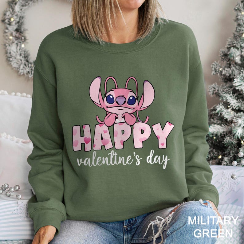 a woman wearing a green sweatshirt with a pink crab on it