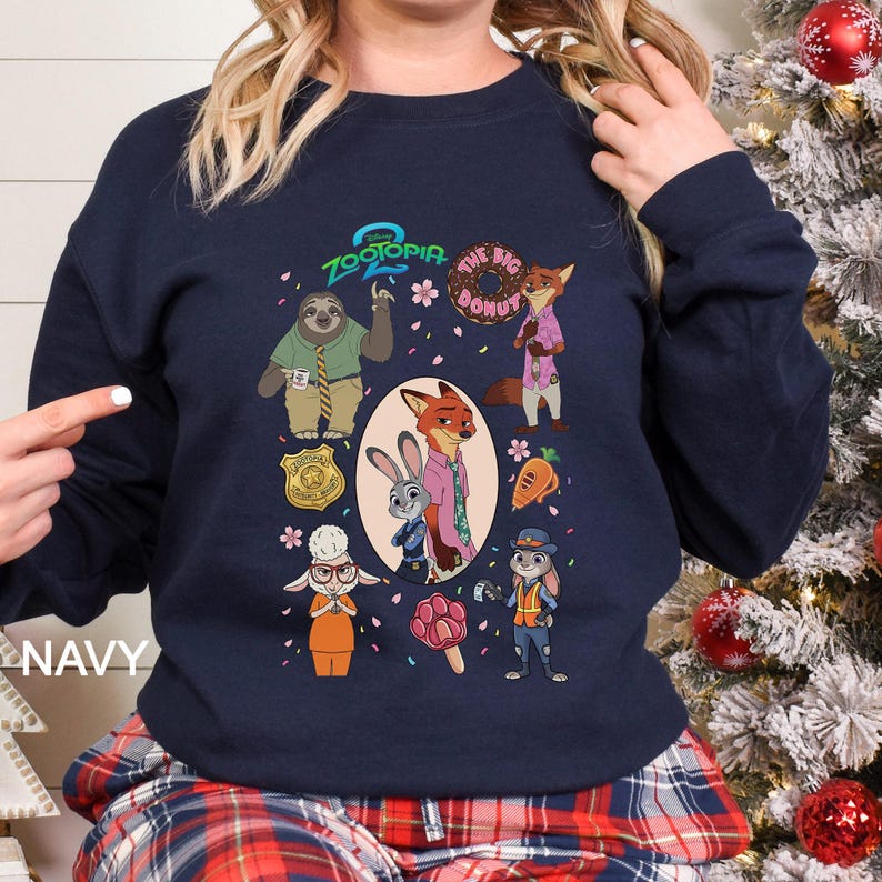 A woman wearing a navy blue sweatshirt with a graphic design featuring various cartoon animal characters, including a sloth, fox, rabbit, and police officer.