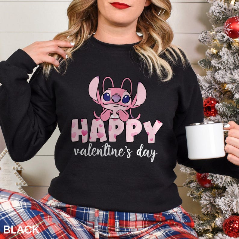 a woman holding a coffee mug in front of a christmas tree