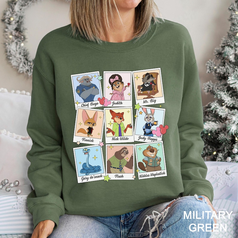 A woman wearing a green sweatshirt with a collage of cartoon animal characters on it.