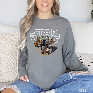 a woman sitting on a couch wearing a star wars shirt