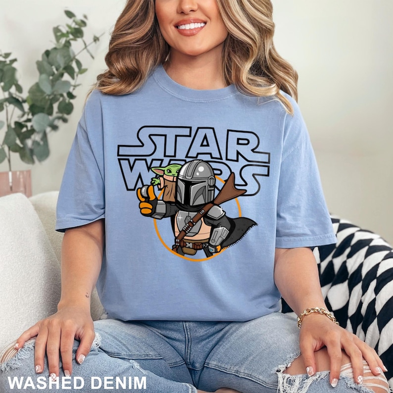a woman sitting on a couch wearing a star wars shirt