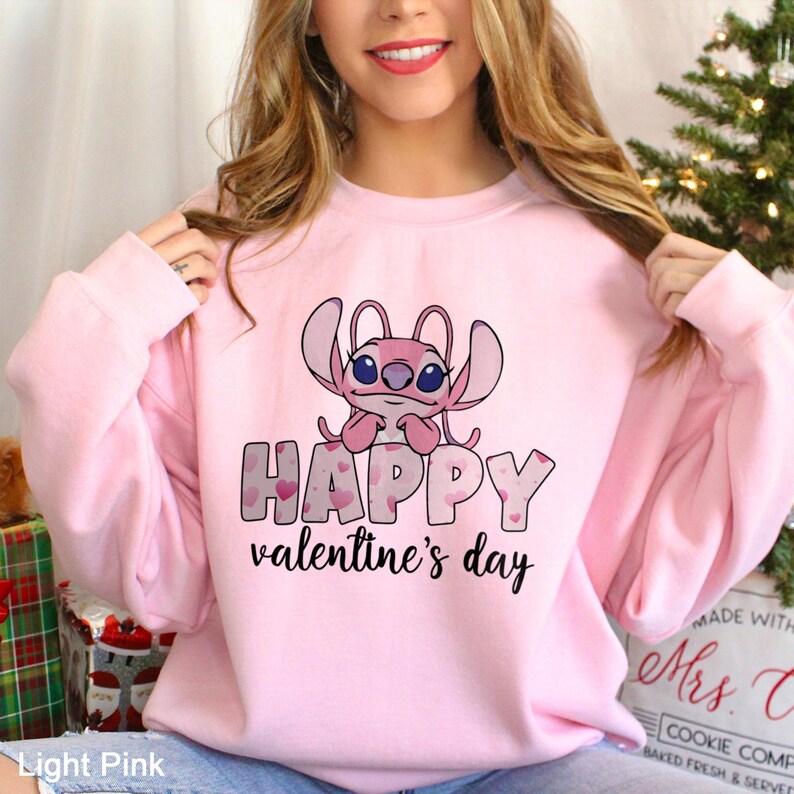 a woman wearing a pink happy valentine's day sweatshirt