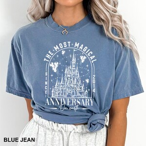 a woman wearing a blue shirt with a castle on it