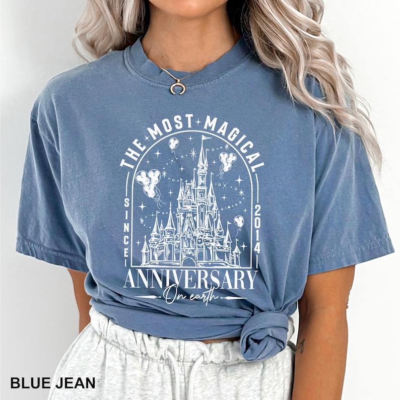 a woman wearing a blue shirt with a castle on it