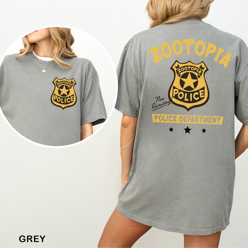 A grey t-shirt with a yellow and black police department badge and text on the back.