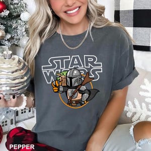 a woman sitting on a couch wearing a star wars shirt