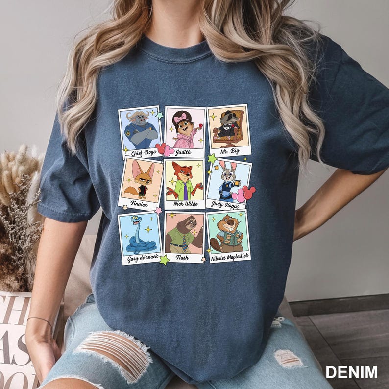 A woman wearing a blue t-shirt with a graphic design of cartoon animal characters and their names.