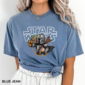 a woman wearing a blue star wars t - shirt