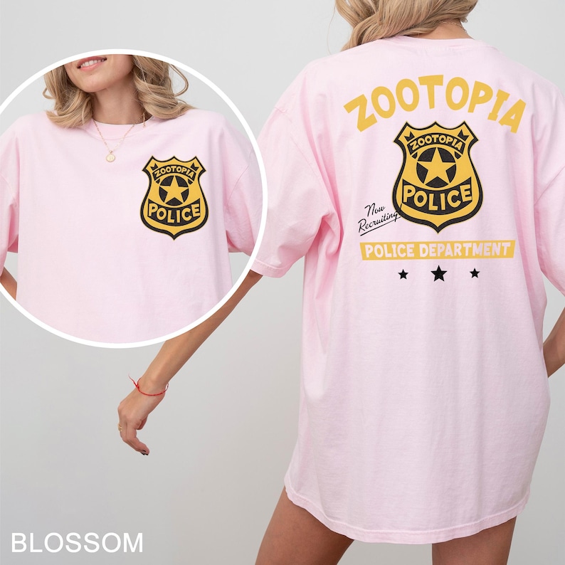 A woman wearing a pink t-shirt with a police department logo on it.