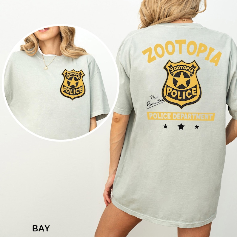 A woman wearing a grey t-shirt with a police department logo and text on the back.