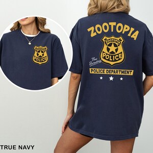 A woman wearing a navy blue t-shirt with the text "Zootopia Police Department" printed on it.