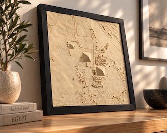 May include: A square, black-framed wall art piece featuring a light-colored, three-dimensional topographic map of the Giza plateau. The relief sculpture displays the three main pyramids, surrounding structures, and intricate terrain contour lines.