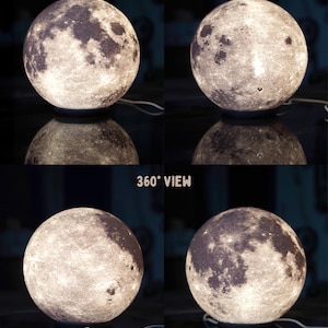 May include: A spherical lamp resembling the moon, with detailed surface textures and craters. The lamp emits a soft, warm glow, and is shown from multiple angles. The text "360&deg; VIEW" is visible.
