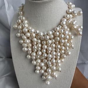 May include: A set of three ceramic mugs with a speckled, cream-colored glaze. Each mug features a different hand-painted floral design in shades of blue, green, and yellow. The mugs have a simple, rounded shape.