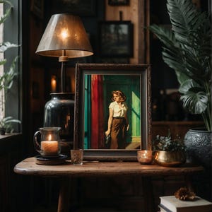 May include: A vintage-style framed painting of a woman standing in a doorway with a red curtain behind her. The painting is on a wooden table with a lamp, candles, and books.