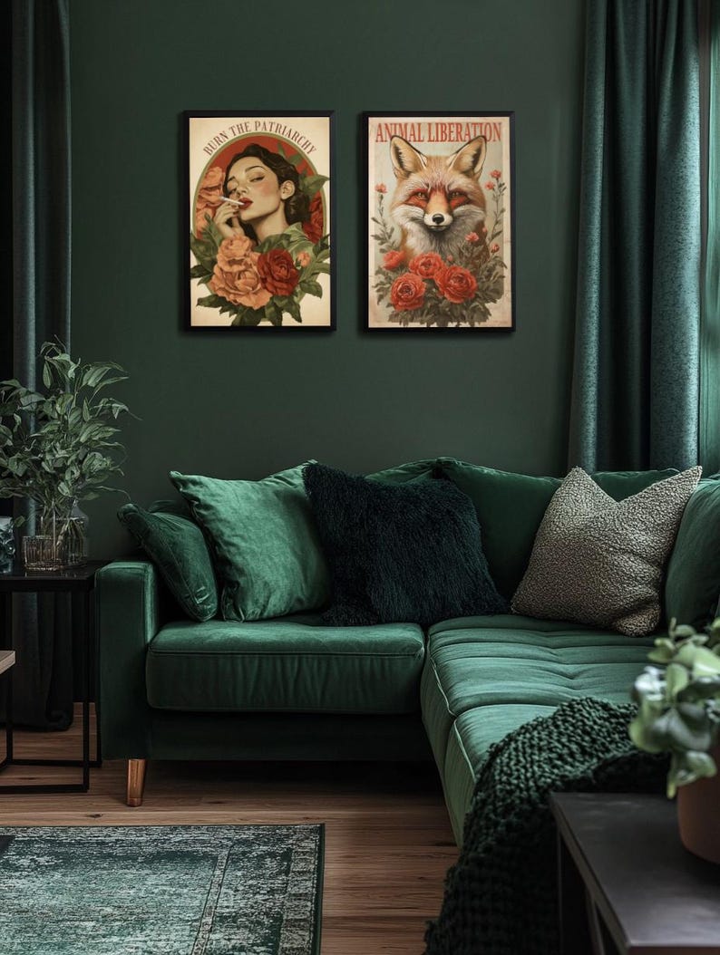 K&ouml;nnte beinhalten: Zwei gerahmte Poster an einer gr&uuml;nen Wand &uuml;ber einem gr&uuml;nen Samtsofa. Das Poster links zeigt eine Frau mit roten Lippen und einer Zigarette, umgeben von roten Rosen. Der Text auf dem Poster lautet "Burn the Patriarchy". Das Poster rechts zeigt einen roten Fuchs mit roten Rosen. Der Text auf dem Poster lautet "Animal Liberation".